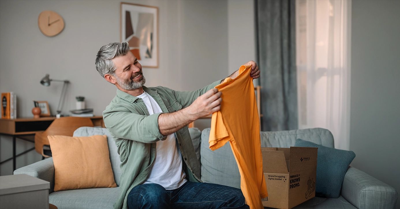 A customer admiring an orange promotional shirt.